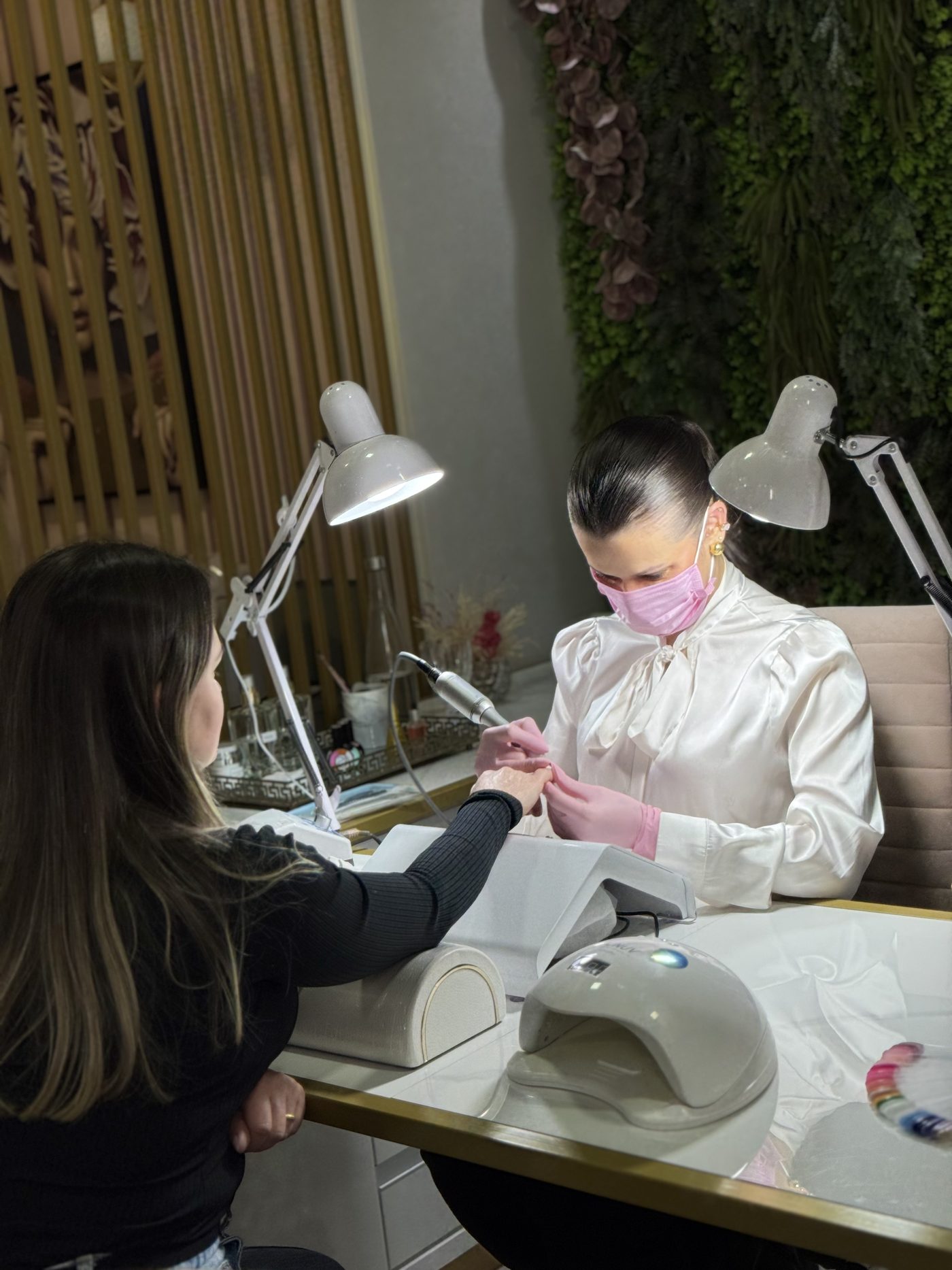 Kethlin Barhfeld atendendo uma cliente em seu estúdio de unhas