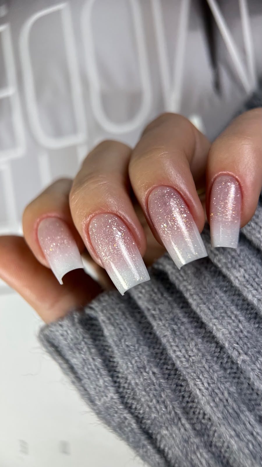 Unhas longas em degradê rosé com glitter perolado